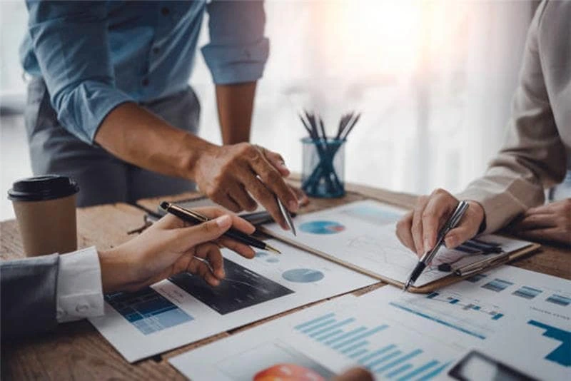 Second charge mortgage lenders discussing a complex business or lending strategy using financial charts, graphs, and papers