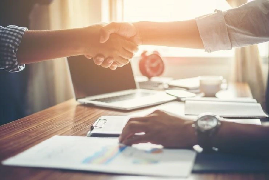 Handshake between professionals discussing commercial property refinancing and mortgage advice in the UK