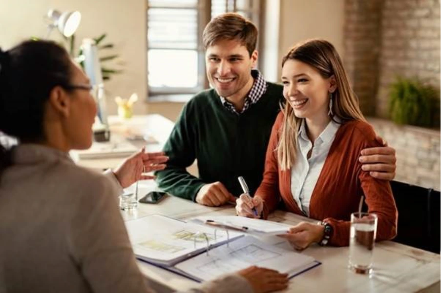 couple meeting with commercial finance broker reviewing property plans representing the refinance stage of an HMO conversion from bridging to term lending